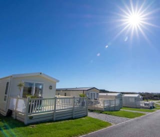 Holiday caravans line down the road, with a big blue sky above and the sun shining brightly.