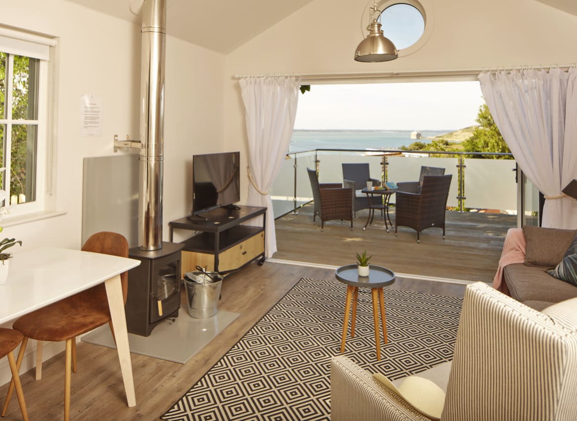 The living area of one of our spacious Beach Lodges, with stunning views of the sea from the balcony. Book your holiday now! image