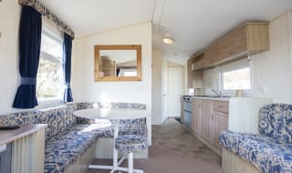 The living and dining area of one of our budget-friendly value static caravans. The perfect way to stay. image