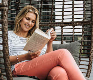 Smiling lady enjoying her book at one of our parks.