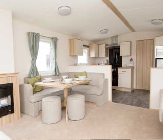 The living and dining area of our bright and spacious comfort static caravan. The perfect way to stay.