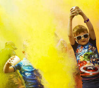 A colour festival event at one of our holiday parks. The young children are splashing colourful substances into the air at our incredible event. image
