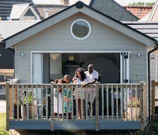 A family on the decking looking out onto the lake at our stunning resort, The Bay Filey.