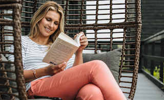 Smiling lady enjoying her book at one of our parks. image
