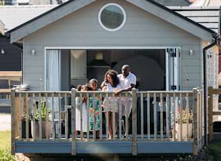 A family on the decking looking out onto the lake at our stunning resort, The Bay Filey. image