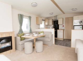The living and dining area of our bright and spacious comfort static caravan. The perfect way to stay. image