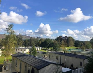An aerial view above the roofs of holiday caravans in Moffat Manor, with hills in the distance. image