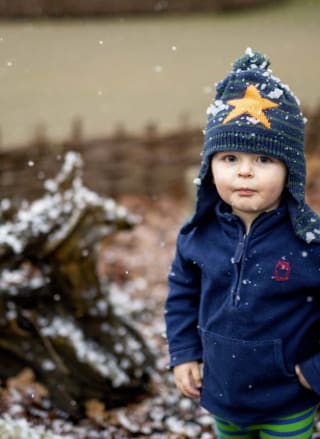A young boy playing in the snow during the festive period.