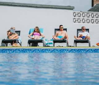 A family enjoying a sunny day at the outdoor heated pool at Bude Holiday Resort.