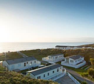 A path leading to the beach with holiday caravans on either side of the path. image