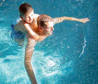 A father and son duo having a swim in one of our indoor pools at our static caravan holiday parks.