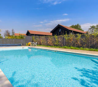 An image of the outdoor heated swimming pool on a sunny day at The Lakes Rookley on the Isle of Wight. image