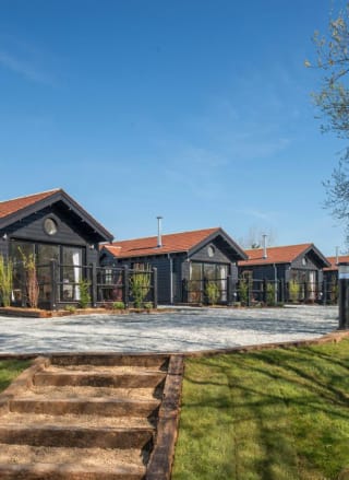 A row of holiday homes at The Lakes Rookley, Isle of Wight, on a sunny day. Explore our stunning accommodation options.