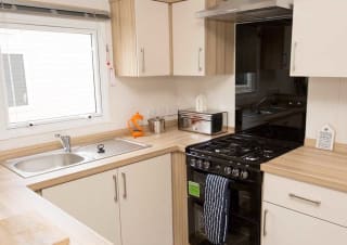 The kitchen area of our bright and spacious comfort static caravan. The perfect way to stay.