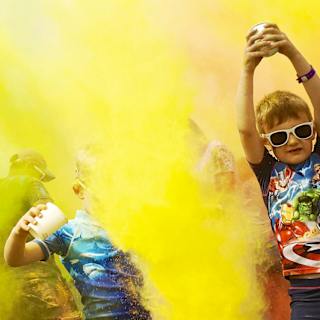 A colour festival event at one of our holiday parks. The young children are splashing colourful substances into the air at our incredible event. image