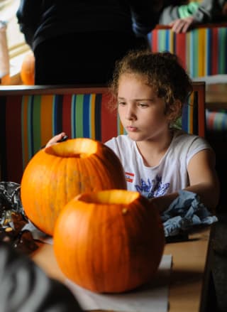 A young girl carving pumpkins at our holiday park.