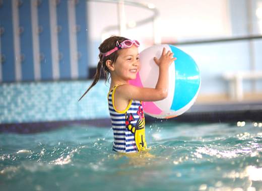 A young girl playing in a indoor pool at our caravan holiday park Golden Sands, North Wales.