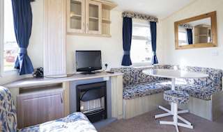 The dining and living area of one of our budget-friendly value static caravans. The perfect way to stay. image