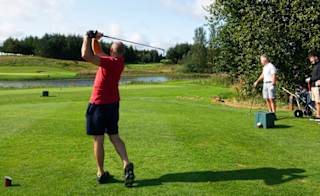 A group of people playing golf on a sunny, cloudy day at Piperdam, Scotland. image