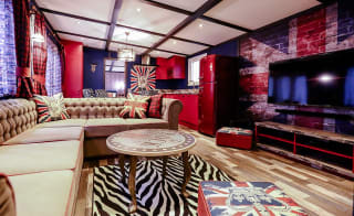 The lounge in our Rockstar holiday home. There’s a spacious kitchen, a large TV and sofa, and a theme of red, white, and blue Great British colours. image