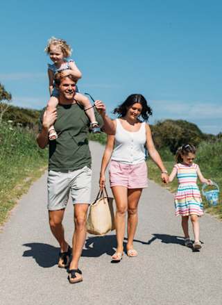 A young family enjoying a stroll together on a summers day.