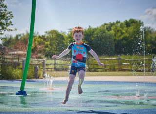 Child running through splashpad at Appletree Holiday Park. image