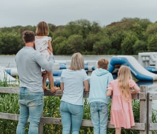 A young family looking over the watersports taking place on the lake at our stunning Retallack Resort & Spa.