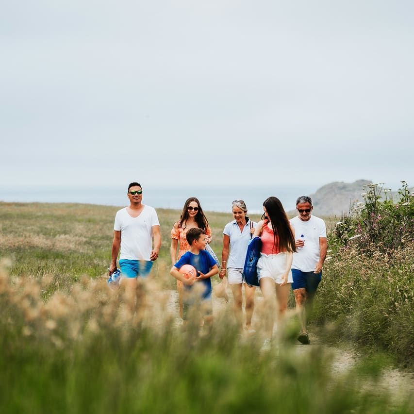 A family enjoying a peaceful stroll to the Cornish coastline on a summers day.