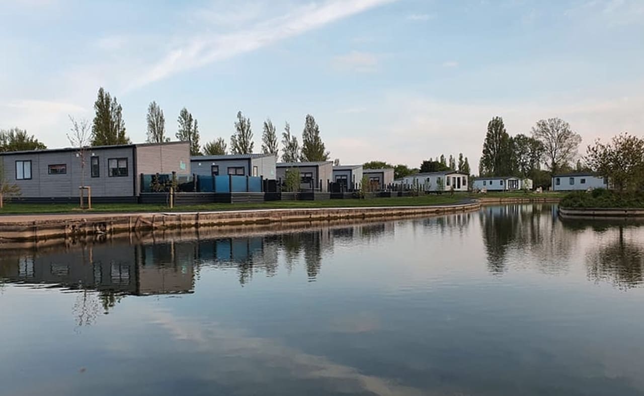 A view of our stunning holiday homes over the lake at Mill Rythe, Hampshire. image