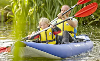 A man and child canoeing down the lake. image