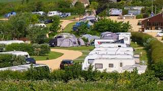 Mobile caravans parked with a wide angle view of the vast countryside and the lagoon located at our East Fleet Farm holiday park in Dorset.