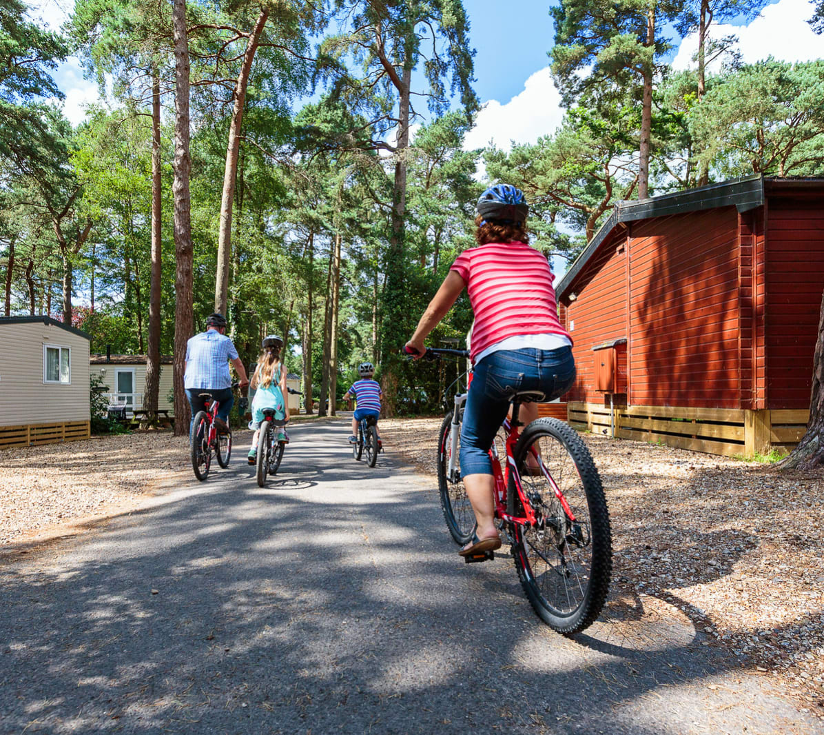 A family cycling together at one of our holiday parks on a sunny day. image