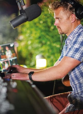 A male performing on a a set of DJ decks.