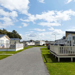 A stone path with holiday caravans seen on either side of the path.