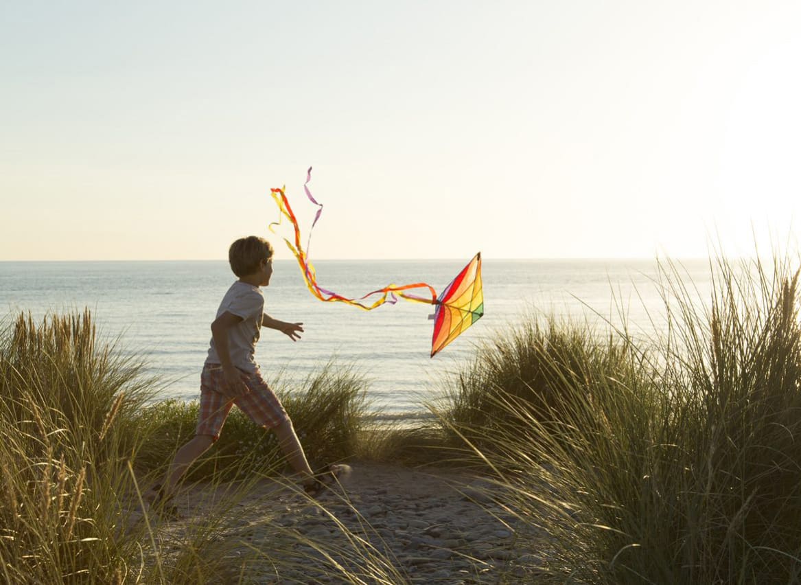 A child flying a kite at sunset over our stunning North Wales holiday park, Barmouth Bay. image