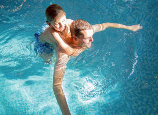 A father and son duo having a swim in one of our indoor pools at our static caravan holiday parks. image