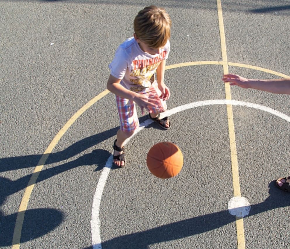 A boy playing basketball in our holiday park.