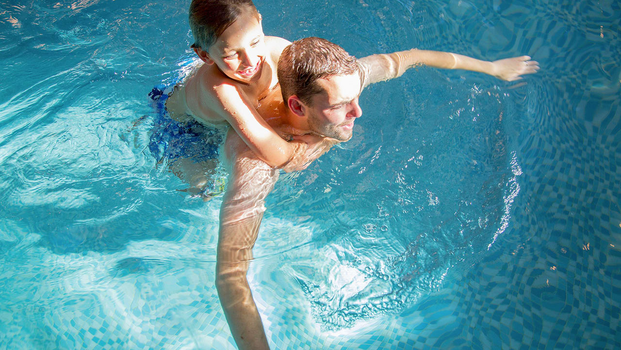 A father and son duo having a swim in one of our indoor pools at our static caravan holiday parks.