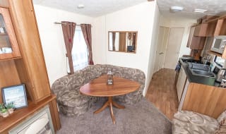 The dining area of our budget-friendly value static caravan. The perfect way to stay. image