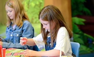 A young girl participating in our slime workshop activity. image