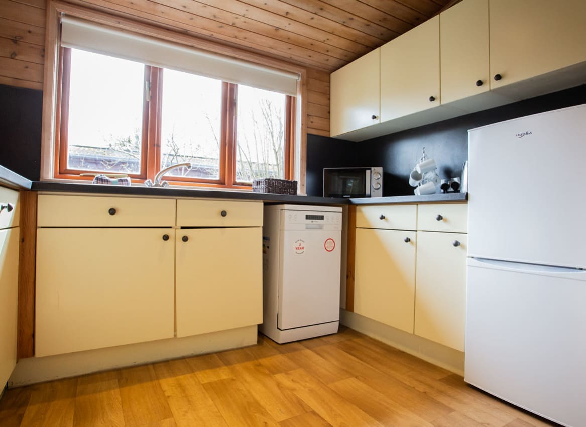 The interior of one of our woodland style holiday lodges. There's a spacious kitchen with various appliances. image