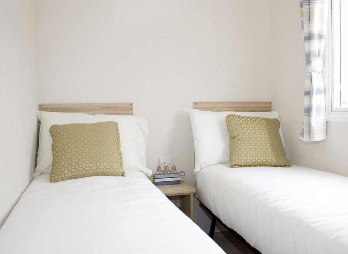 The twin bedroom in our bright and spacious comfort static caravan. The perfect way to stay. image