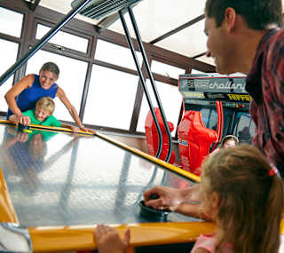A family playing at the arcades at our holiday park in North Wales, Golden Sands. image