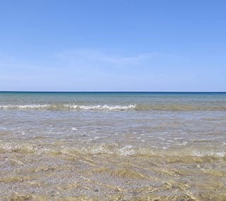 Rolling waves on a bright summers day at a lagoon in Dorset. image