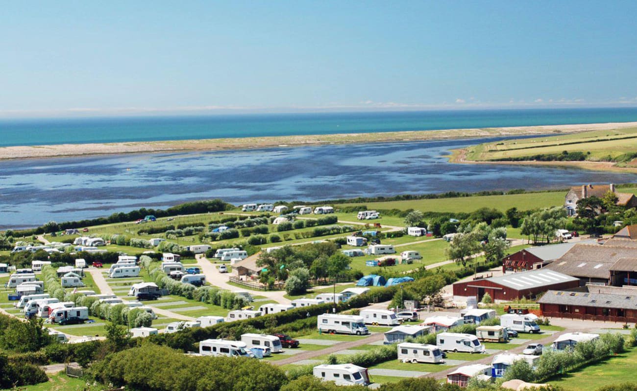 A bright sunny day overlooking our East Fleet Farm holiday park in Dorset. There are vast areas of countryside and a river to the horizon. image