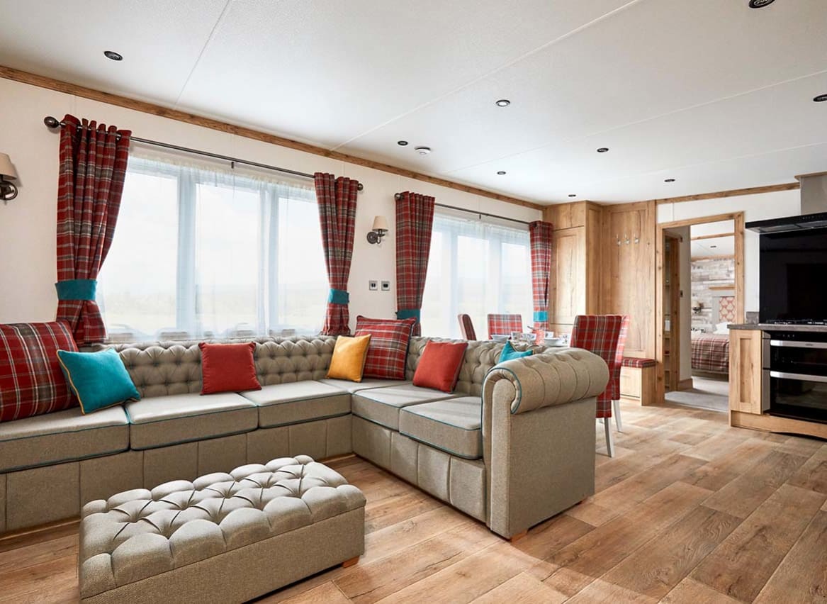 The Heartwood holiday home lounge area. This space has a large sofa, a dining area, and décor that reflects Scottish baronial living. image