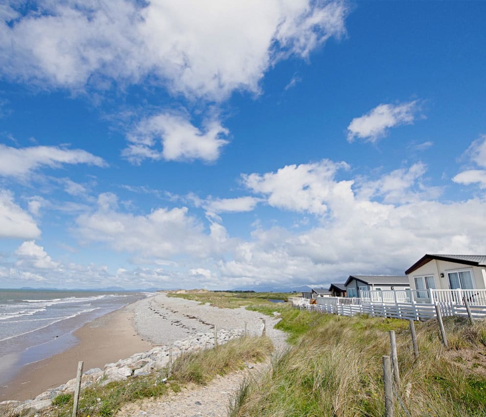 A sunny, cloudy day overlooking the beach at Barmouth Bay, North Wales. Book now to stay in one of our luxury static caravans.