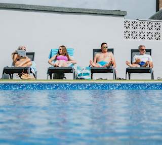 A family enjoying a sunny day at the outdoor heated pool at Bude Holiday Resort. image