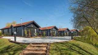 A row of holiday homes at The Lakes Rookley, Isle of Wight, on a sunny day. Explore our stunning accommodation options. image