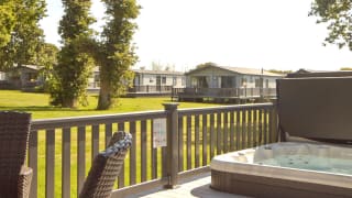 The decking with a hot tub of one of our stunning accommodations at St Helens Coastal Resort. image